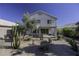 An immaculate two-story home, showcasing a beautifully landscaped backyard with desert plants and a covered patio at 4530 E Desert Wind Dr, Phoenix, AZ 85044