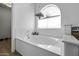 This elegant soaking tub is complemented by a garden view and decorative tile at 4530 E Desert Wind Dr, Phoenix, AZ 85044