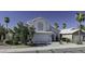 Charming two-story home featuring a white exterior, arched window, and a well-manicured desert landscape at 4530 E Desert Wind Dr, Phoenix, AZ 85044