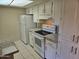 Kitchen with white appliances, granite countertops, white cabinets and tile flooring at 461 W Holmes Ave # 360, Mesa, AZ 85210