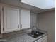 Well-maintained kitchen with white cabinets, sleek granite countertops, and a stainless steel sink at 461 W Holmes Ave # 360, Mesa, AZ 85210
