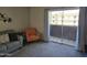 Cozy living room featuring a sofa and orange chair, offering a view of the outdoor building from the balcony at 461 W Holmes Ave # 360, Mesa, AZ 85210