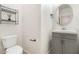 This half bathroom has a grey vanity, oval mirror, and toilet next to shelving at 4716 E Red Oak Ln # 102, Gilbert, AZ 85297