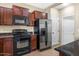 This kitchen has stainless steel refrigerator, dark cabinetry, and granite countertops at 4716 E Red Oak Ln # 102, Gilbert, AZ 85297