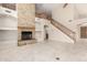 Open-concept living room boasting a stone fireplace and adjacent staircase at 4801 E Quien Sabe Way, Cave Creek, AZ 85331