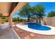 Backyard pool with rock waterfall feature, surrounded by lush greenery, perfect for relaxation at 4801 E Quien Sabe Way, Cave Creek, AZ 85331