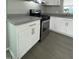 Updated kitchen boasts white cabinets, a stainless steel oven range, and gray countertops at 500 N 67 Ave # 149, Phoenix, AZ 85043