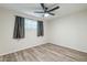 A cozy bedroom with hardwood-style flooring, a ceiling fan, and a window at 505 W Howe St, Tempe, AZ 85281