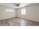Bright bedroom boasts hardwood-style floors, a ceiling fan, and a decorative stained glass window at 505 W Howe St, Tempe, AZ 85281