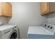 Functional laundry room with washer, dryer, and overhead cabinets at 505 W Howe St, Tempe, AZ 85281