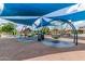 Community playground area with swings and shade structure on a sunny day at 5460 S Dillon Cir, Mesa, AZ 85212
