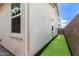 Narrow side yard featuring artificial turf and a stucco privacy wall at 5460 S Dillon Cir, Mesa, AZ 85212