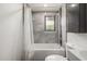 Bright bathroom featuring a shower with a tub and grey tiles at 5739 N 11Th St, Phoenix, AZ 85014
