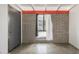 Bedroom with concrete floors, a brick accent wall, and modern grey door with hardware at 5739 N 11Th St, Phoenix, AZ 85014