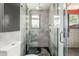 Stylish walk-in shower with tiled walls, glass door, and window offering natural light at 5739 N 11Th St, Phoenix, AZ 85014