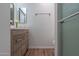 Bathroom featuring wood-grain vanity, toilet, tile floors, and glass-enclosed shower at 6044 W Augusta Ave, Glendale, AZ 85301