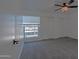 Carpeted bedroom with ceiling fan and a window with bars, providing ample natural light at 6044 W Augusta Ave, Glendale, AZ 85301
