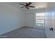 Bedroom with a fan, carpet, window with security bars, and a closet with folding doors at 6044 W Augusta Ave, Glendale, AZ 85301