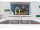 Close-up of kitchen sink with white cabinets and modern faucet fixtures at 6044 W Augusta Ave, Glendale, AZ 85301