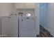 This laundry room features a white washer and dryer, as well as white cabinets for storage at 6044 W Augusta Ave, Glendale, AZ 85301