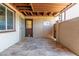 Spacious patio with neutral flooring, wood beam ceiling, and gated entry door at 6044 W Augusta Ave, Glendale, AZ 85301