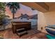 Backyard area featuring a hot tub, palm trees, and lush green landscaping at 6133 E Saddleback St, Mesa, AZ 85215