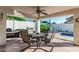 Covered patio with ceiling fan and outdoor dining area with table and chairs at 6133 E Saddleback St, Mesa, AZ 85215