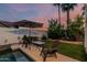 Inviting backyard featuring a pool with a sitting area and a well-manicured garden at 6133 E Saddleback St, Mesa, AZ 85215