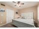 Comfortable bedroom features white closet doors, a ceiling fan, and a charming white wood bed frame at 6133 E Saddleback St, Mesa, AZ 85215