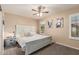 Serene bedroom with a white wood-framed bed, ceiling fan, and soft natural light at 6133 E Saddleback St, Mesa, AZ 85215