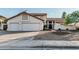 Exterior view of a home with desert landscaping, a tile roof, and a spacious three-car garage at 6133 E Saddleback St, Mesa, AZ 85215