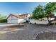 Charming two-story home with desert landscaping, a tile roof, and a spacious three-car garage at 6133 E Saddleback St, Mesa, AZ 85215