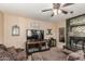 Living room featuring dark tile fireplace, wood-look tile flooring, and media center at 6133 E Saddleback St, Mesa, AZ 85215