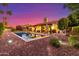 Backyard with a pool, patio, mature trees, shrubs, and landscape lighting under a twilight sky at 650 E Silver Creek Rd, Gilbert, AZ 85296