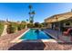 Backyard swimming pool, patio area with umbrella, and mature landscaping on a sunny day at 650 E Silver Creek Rd, Gilbert, AZ 85296
