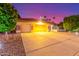 Expansive driveway leading to a home featuring a three-car garage under an ambient dusk sky at 650 E Silver Creek Rd, Gilbert, AZ 85296