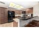Modern kitchen featuring dark wood cabinets, granite countertops, and stainless steel appliances under a skylight at 650 E Silver Creek Rd, Gilbert, AZ 85296