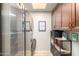 Spacious laundry room with storage cabinets, modern washer/dryer, and decor art at 650 E Silver Creek Rd, Gilbert, AZ 85296