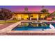 Backyard pool with patio, green space, and string lights illuminating the outdoor space at dusk at 650 E Silver Creek Rd, Gilbert, AZ 85296