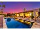 Backyard pool with patio, mature trees, and landscape lighting creating a private retreat under a colorful sky at 650 E Silver Creek Rd, Gilbert, AZ 85296