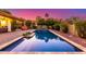 Backyard swimming pool with a tiled edge and patio, surrounded by mature landscaping and a colorful sky at 650 E Silver Creek Rd, Gilbert, AZ 85296