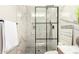 Modern bathroom with a glass shower, marble walls, and mosaic tile floor at 6751 W Cameron Dr, Peoria, AZ 85345