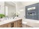 Stylish bathroom featuring a wooden vanity and separate tub with blue tile at 6751 W Cameron Dr, Peoria, AZ 85345