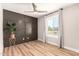 Comfortable bedroom with wood-look floors, decorative accent wall, and lots of natural light at 6751 W Cameron Dr, Peoria, AZ 85345