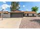 Charming single-story home featuring a gray brick garage and low maintenance rock landscaping at 6751 W Cameron Dr, Peoria, AZ 85345