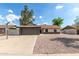 Charming single-story home featuring a gray brick garage, basketball hoop and low maintenance rock landscaping at 6751 W Cameron Dr, Peoria, AZ 85345
