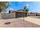 View of the side of the house with a gray brick garage, basketball hoop and low maintenance rock landscaping at 6751 W Cameron Dr, Peoria, AZ 85345