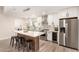 Modern kitchen with stainless steel appliances, custom backsplash and island with seating for three at 6751 W Cameron Dr, Peoria, AZ 85345