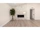 Open-concept living room featuring a modern fireplace, wood-look tile floors and a vaulted ceiling at 6751 W Cameron Dr, Peoria, AZ 85345