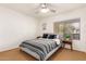 A bright bedroom features a ceiling fan, a modern bed with striped bedding, and a side table with greenery at 7008 E Gold Dust Ave # 236, Scottsdale, AZ 85253